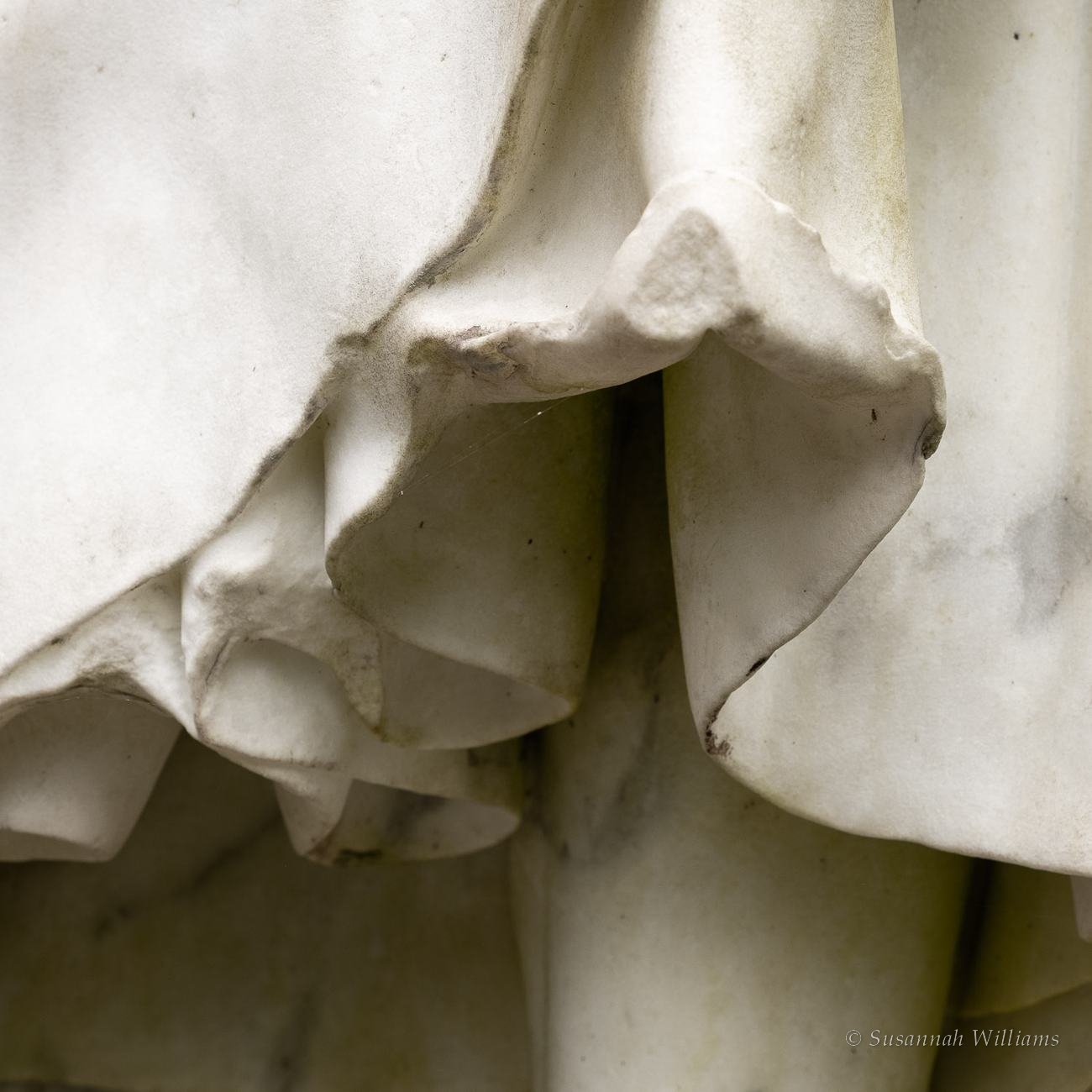 Draped fabric carved in white marble.