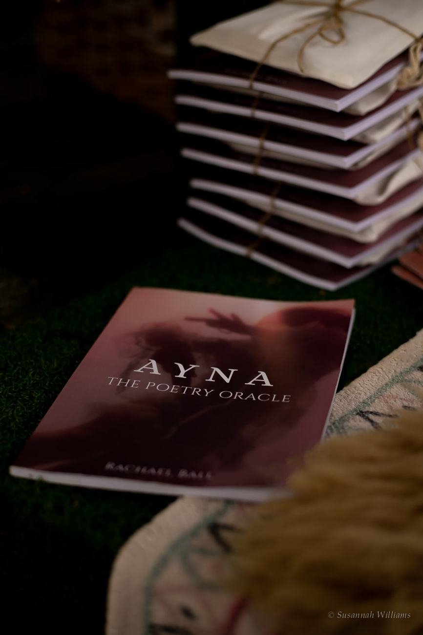 A copy of Ayna: The Poetry Oracle resting on a stack tied with twine.