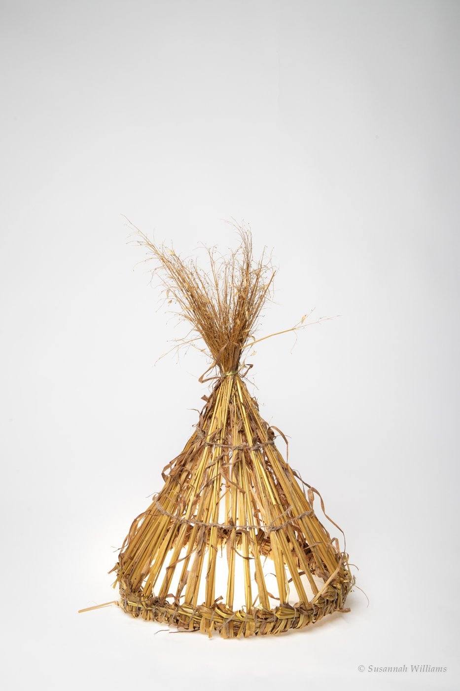 A straw Mummer hat standing on a plain white background.