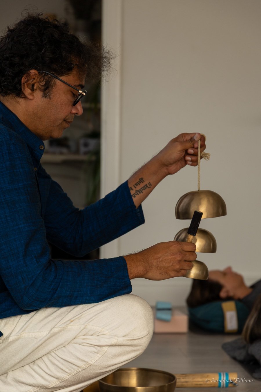 Parag crouching among the bowls, ringing a string of bells.